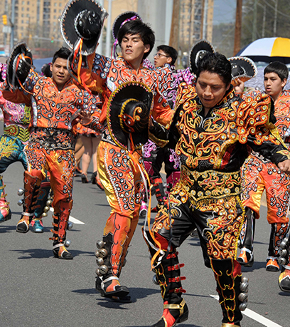 पारंपरिक पोशाक में पुरुष गली में परेड के दौरान गतिशील रूप से घूम रहे होते हैं।