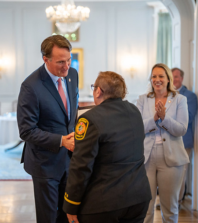 आपातकालीन प्रतिक्रिया देने वाले से हाथ मिलाते हुए गवर्नर