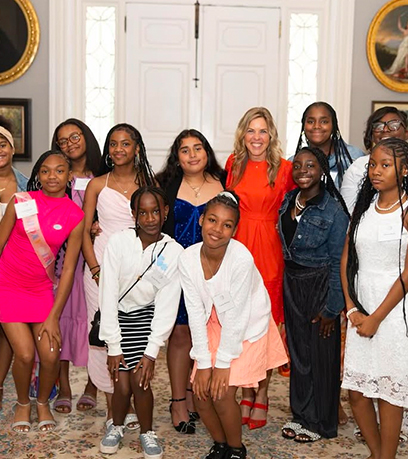 फ़र्स्ट लेडी के साथ युवा लड़कियों का एक समूह